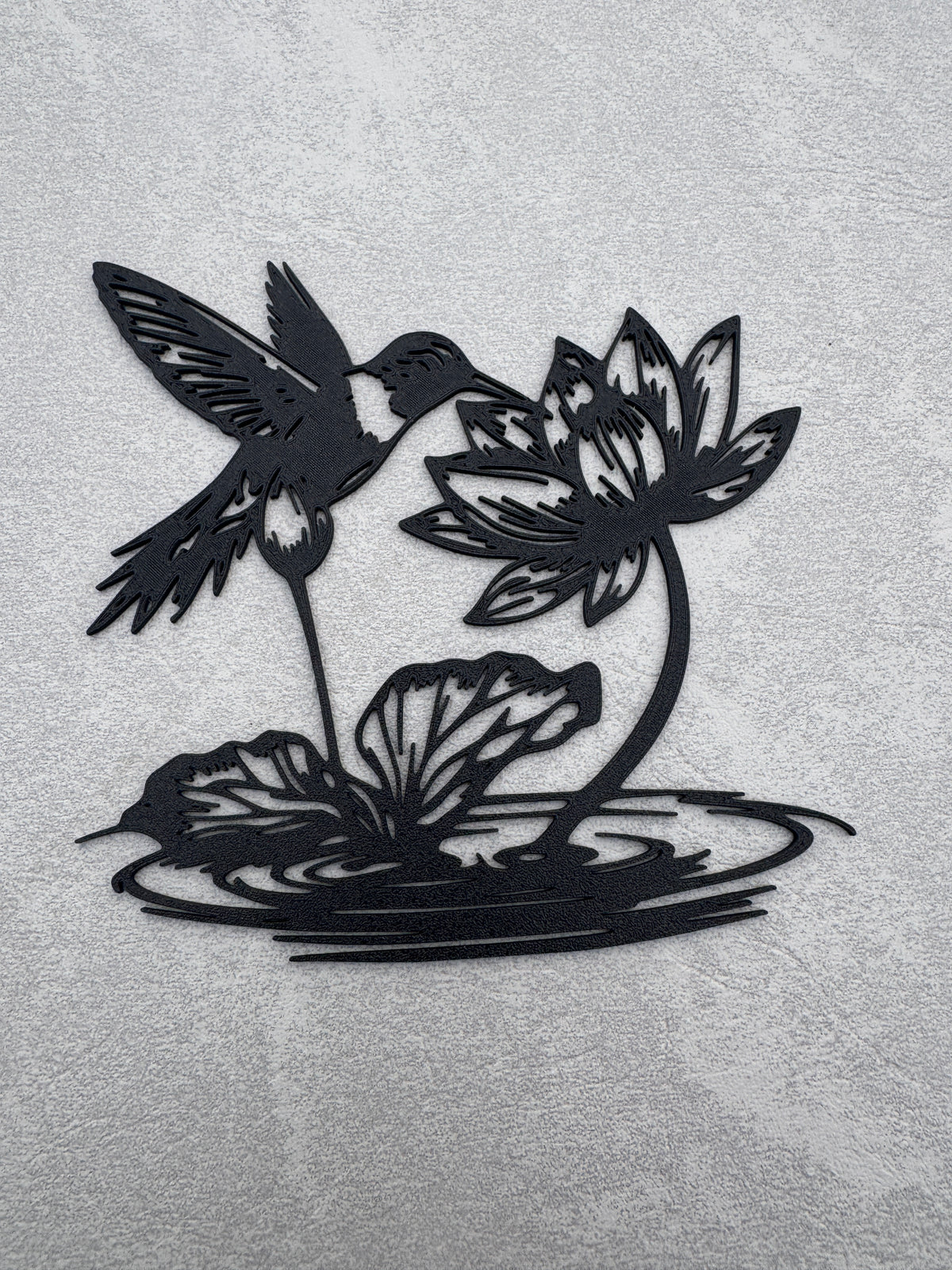 Hummingbird drinking from Flower over water
